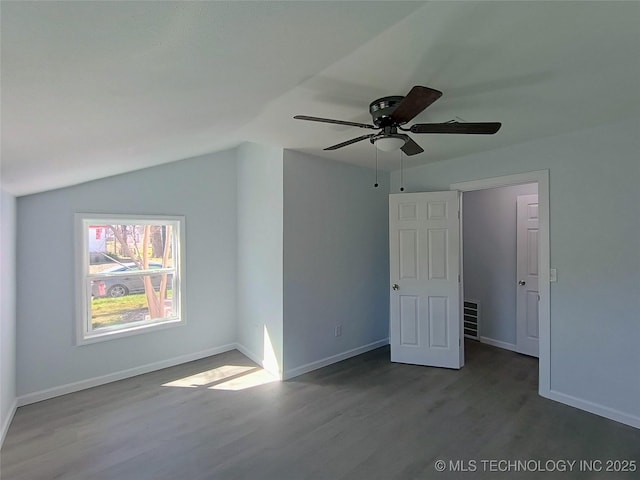 interior space with visible vents, lofted ceiling, a ceiling fan, wood finished floors, and baseboards