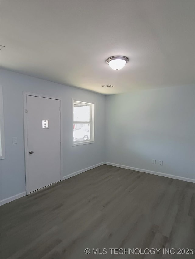 entrance foyer with dark wood-style floors, visible vents, and baseboards