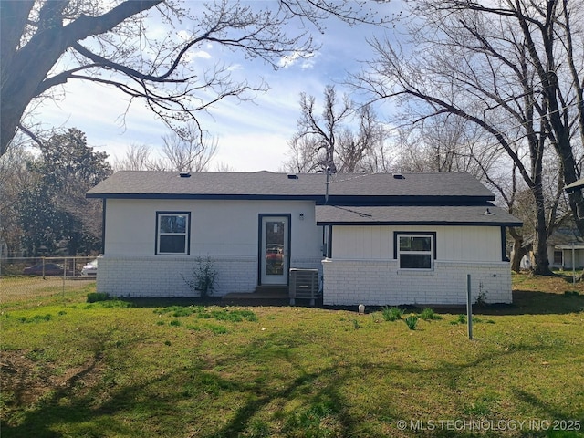 view of front of home featuring brick siding, central AC, and a front lawn