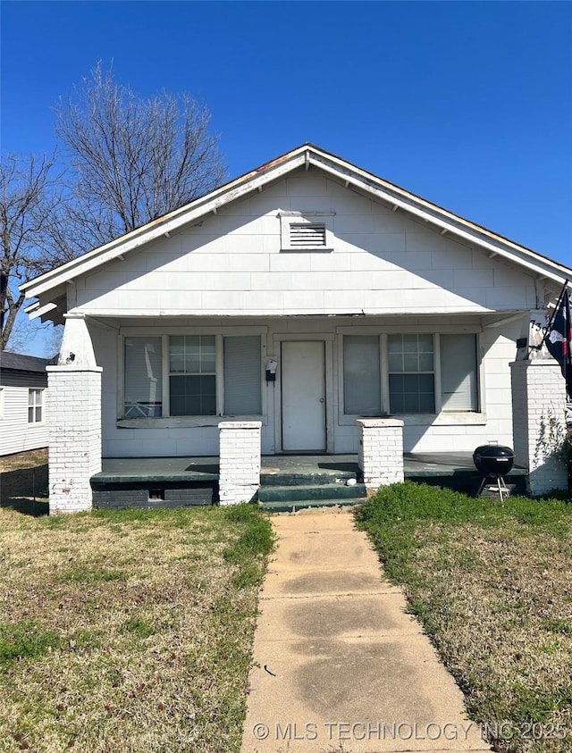 bungalow with a porch and a front yard