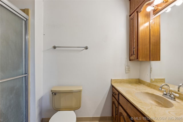 full bath featuring a shower with door, toilet, and vanity