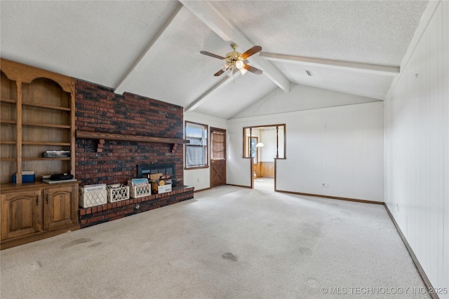 unfurnished living room with lofted ceiling with beams, a textured ceiling, a brick fireplace, and carpet