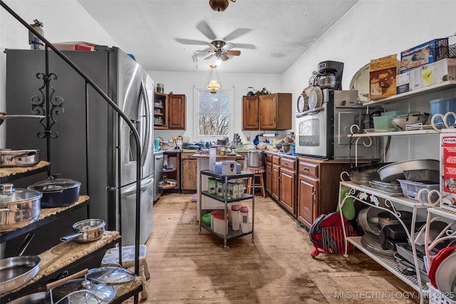 20480 Burneyville, Burneyville, OK 73430 - kitchen featuring a ceiling fan, open shelves, freestanding refrigerator, brown cabinetry, and light wood finished floors