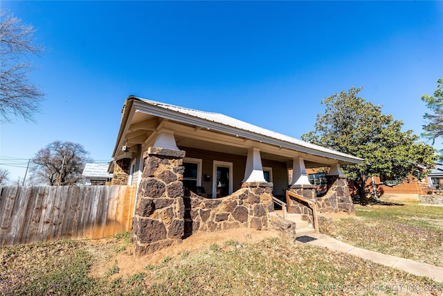 view of front of home with metal roof and fence