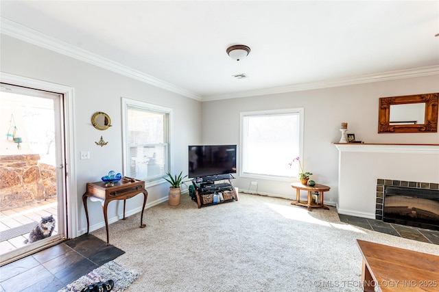 living room featuring baseboards, carpet floors, ornamental molding, and a tiled fireplace