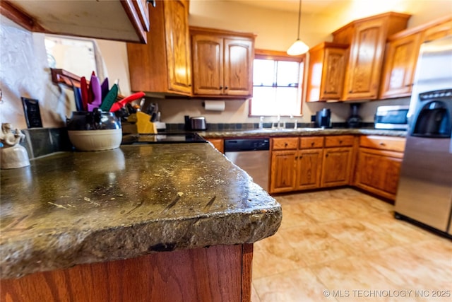 kitchen featuring brown cabinets, appliances with stainless steel finishes, and hanging light fixtures