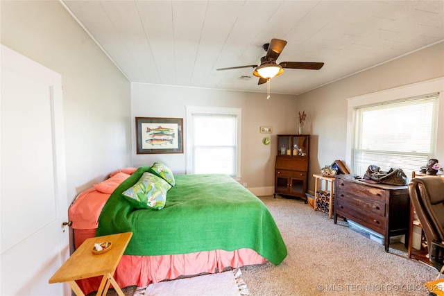 carpeted bedroom with multiple windows and ceiling fan