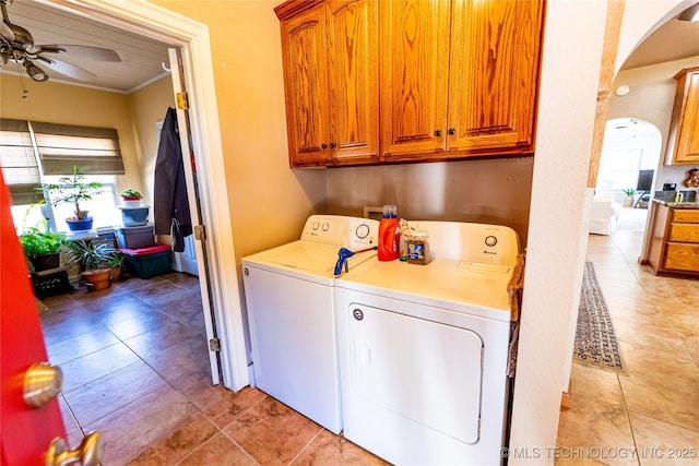 washroom featuring washing machine and clothes dryer, crown molding, arched walkways, cabinet space, and a ceiling fan