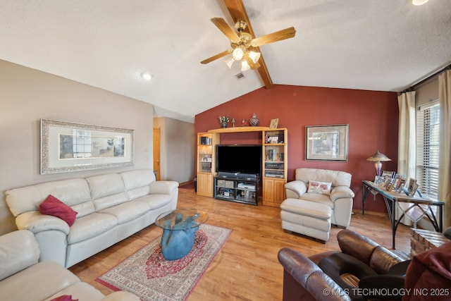 living area with visible vents, a textured ceiling, light wood finished floors, ceiling fan, and vaulted ceiling with beams