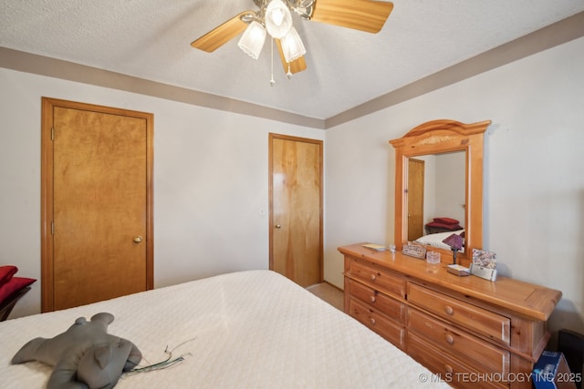 bedroom featuring a ceiling fan, a closet, and a textured ceiling