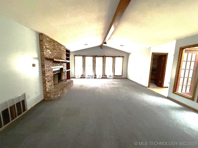 unfurnished living room with lofted ceiling with beams, a healthy amount of sunlight, visible vents, and a textured ceiling