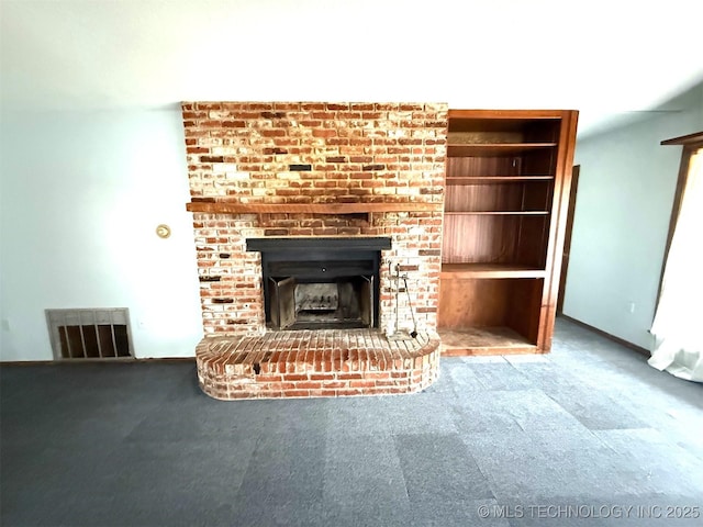 unfurnished living room featuring visible vents, carpet floors, and a brick fireplace