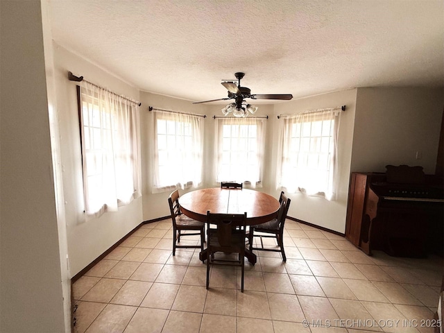 dining area featuring light tile patterned floors, a textured ceiling, baseboards, and a ceiling fan