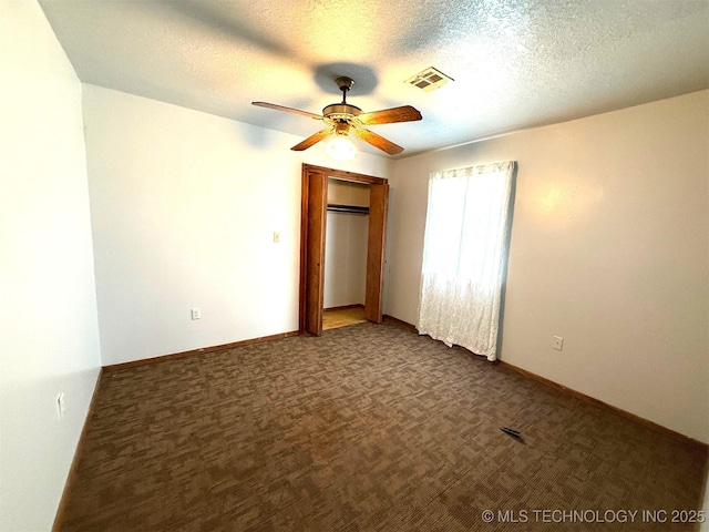 unfurnished bedroom featuring carpet, baseboards, visible vents, a closet, and a textured ceiling