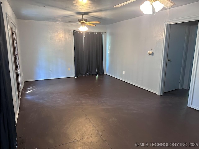 unfurnished room featuring baseboards, concrete flooring, and ceiling fan