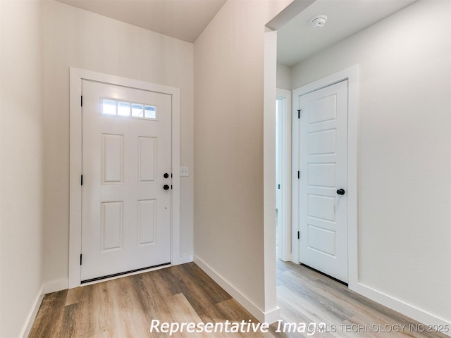 entrance foyer featuring baseboards and wood finished floors