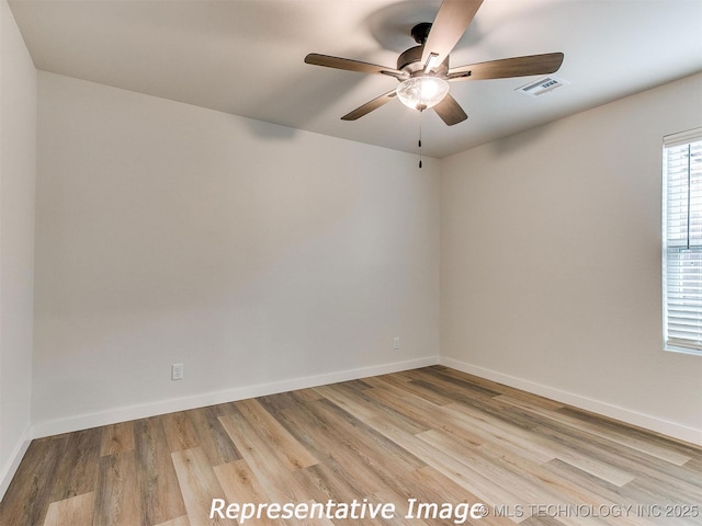 unfurnished room featuring baseboards, visible vents, and light wood finished floors