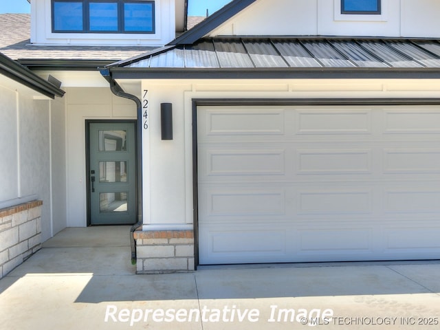 property entrance featuring stucco siding, concrete driveway, and an attached garage