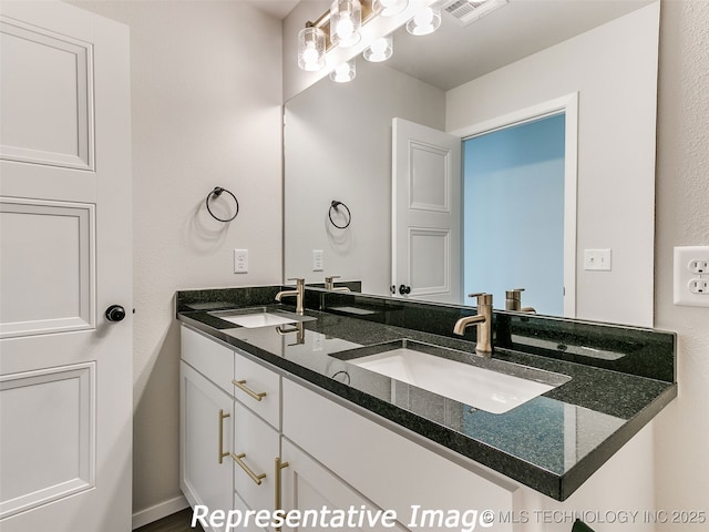 full bath with a sink, visible vents, and double vanity