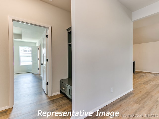 hall with baseboards and wood finished floors