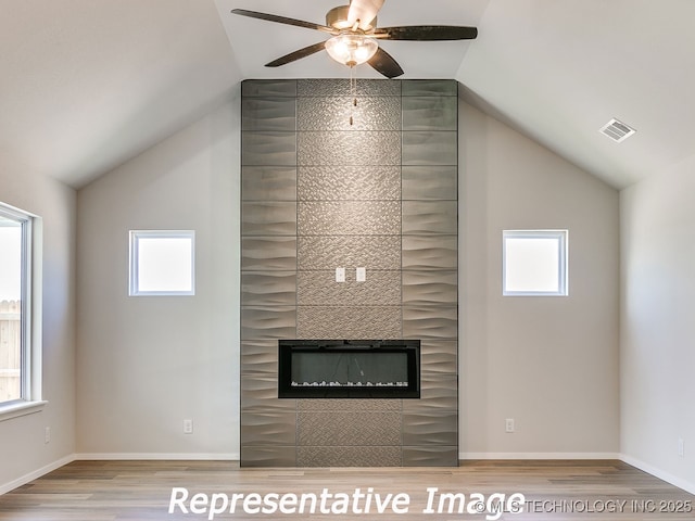 interior details with visible vents, baseboards, a fireplace, wood finished floors, and a ceiling fan