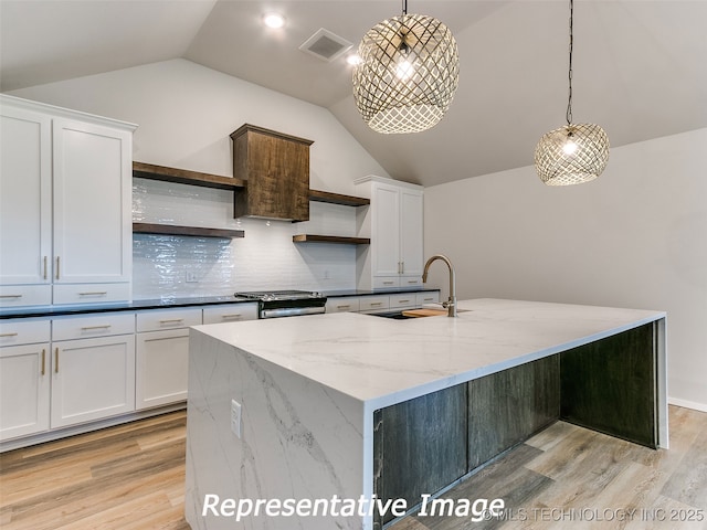 kitchen with stainless steel gas range oven, visible vents, open shelves, white cabinets, and a sink