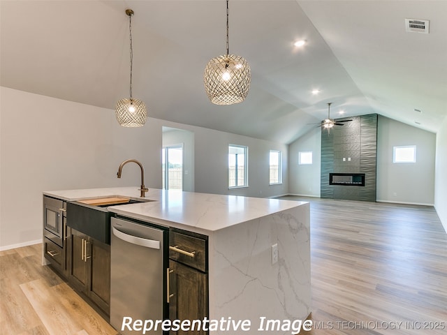 kitchen with visible vents, pendant lighting, stainless steel dishwasher, a fireplace, and light wood finished floors