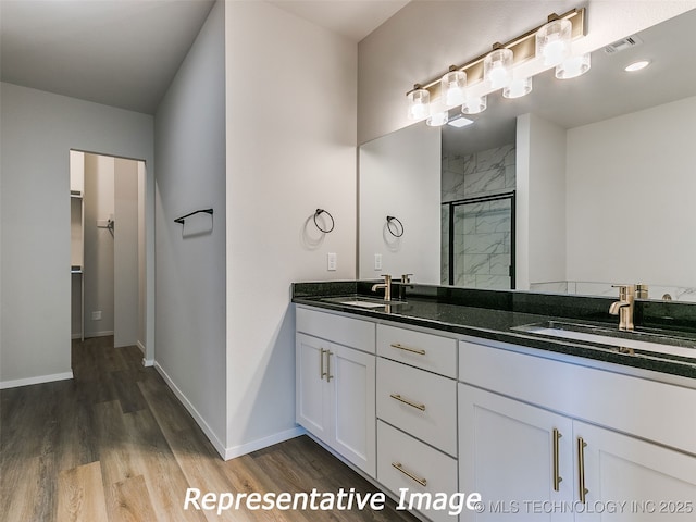 bathroom featuring a sink, visible vents, a stall shower, and double vanity