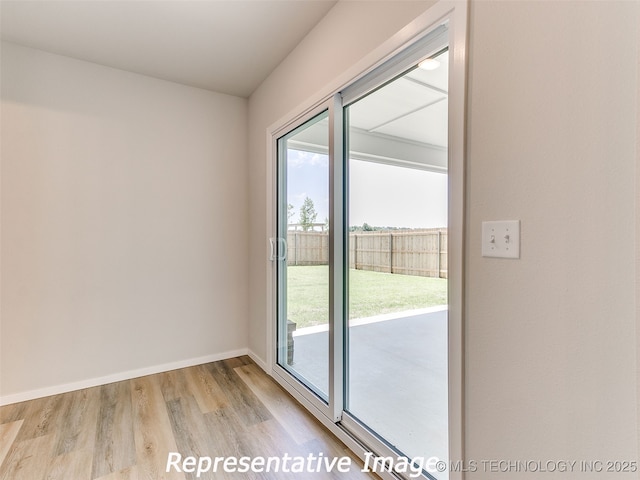 doorway to outside featuring light wood-style flooring, baseboards, and a wealth of natural light