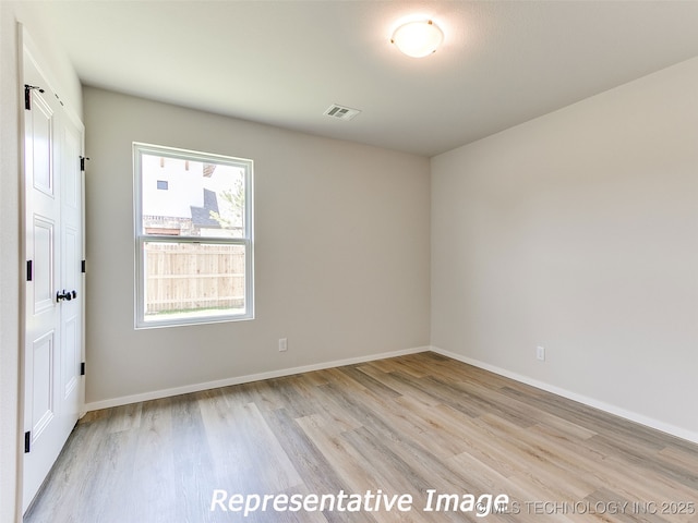 spare room with visible vents, baseboards, and light wood-style floors