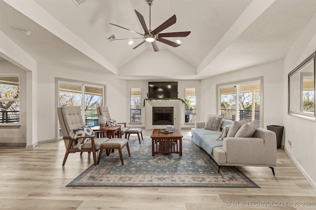 living room featuring baseboards, a fireplace, wood finished floors, high vaulted ceiling, and a ceiling fan