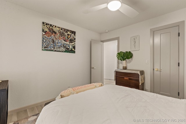 bedroom with wood finished floors, baseboards, and ceiling fan