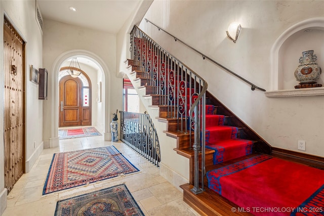 3217 E 61st Pl, Tulsa, OK 74136 - entryway featuring arched walkways, stairway, and baseboards