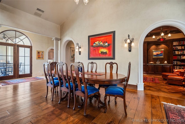 3217 E 61st Pl, Tulsa, OK 74136 - dining room featuring high vaulted ceiling, arched walkways, hardwood / wood-style flooring, and french doors