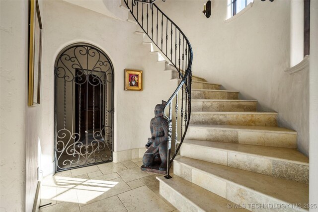 3217 E 61st Pl, Tulsa, OK 74136 - entryway featuring tile patterned flooring, arched walkways, and stairway