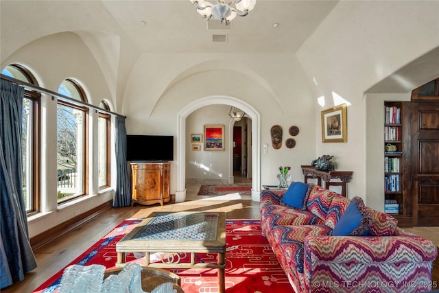 3217 E 61st Pl, Tulsa, OK 74136 - living room with wood-type flooring, arched walkways, and a chandelier