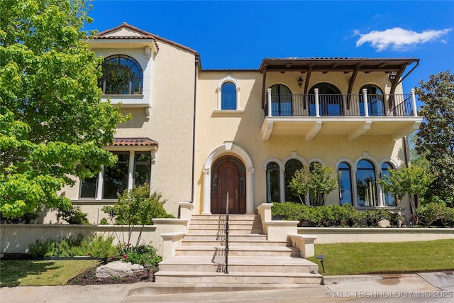 3217 E 61st Pl, Tulsa, OK 74136 - mediterranean / spanish house with a tile roof, stucco siding, and a balcony