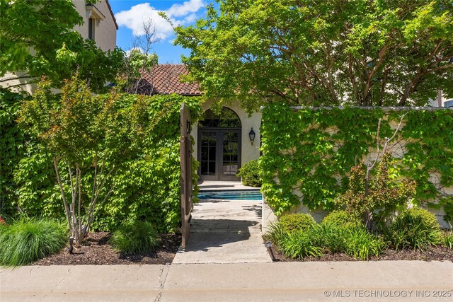 3217 E 61st Pl, Tulsa, OK 74136 - exterior space with an outdoor pool, stucco siding, and french doors