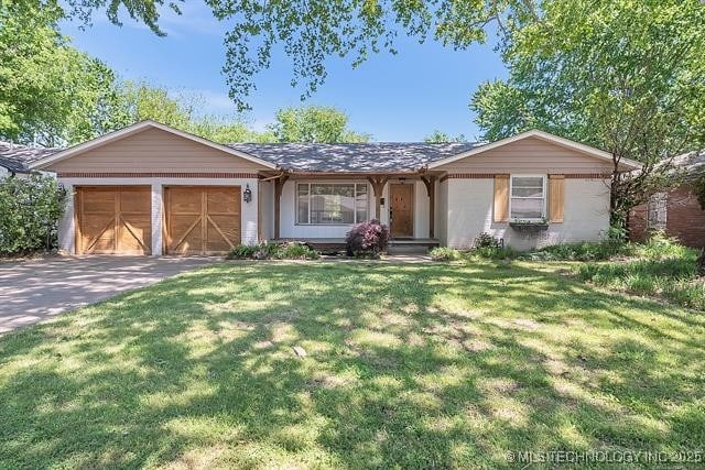 ranch-style house with an attached garage, concrete driveway, and a front lawn