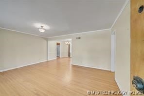 spare room featuring wood finished floors and ornamental molding