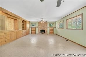 unfurnished living room with finished concrete floors, a fireplace, and ceiling fan