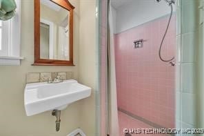 bathroom with walk in shower and a sink