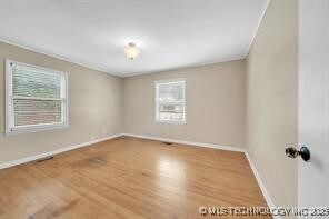 4331 S Norfolk Ave, Tulsa, OK 74105 - empty room featuring plenty of natural light, baseboards, wood finished floors, and crown molding