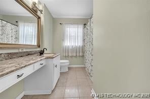 full bathroom featuring tile patterned floors, baseboards, toilet, and vanity