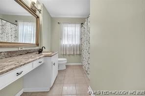 4331 S Norfolk Ave, Tulsa, OK 74105 - full bathroom with toilet, vanity, tile patterned flooring, baseboards, and a shower with curtain
