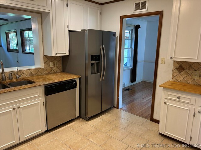 4331 S Norfolk Ave, Tulsa, OK 74105 - kitchen featuring stainless steel appliances, a sink, tasteful backsplash, white cabinets, and healthy amount of natural light