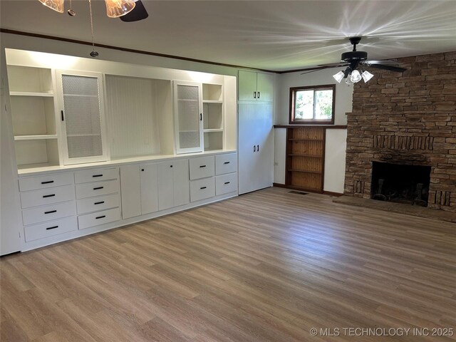 4331 S Norfolk Ave, Tulsa, OK 74105 - unfurnished living room featuring a ceiling fan, wood finished floors, and a stone fireplace