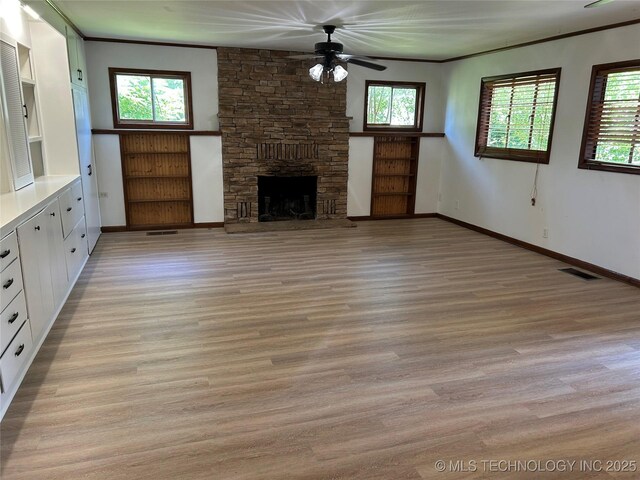 4331 S Norfolk Ave, Tulsa, OK 74105 - unfurnished living room featuring light wood-type flooring, ceiling fan, a fireplace, baseboards, and crown molding