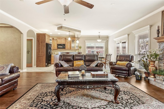 living room featuring recessed lighting, arched walkways, crown molding, light wood finished floors, and ceiling fan