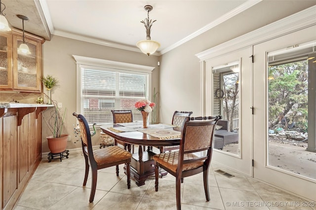 dining room with light tile patterned flooring, plenty of natural light, and crown molding